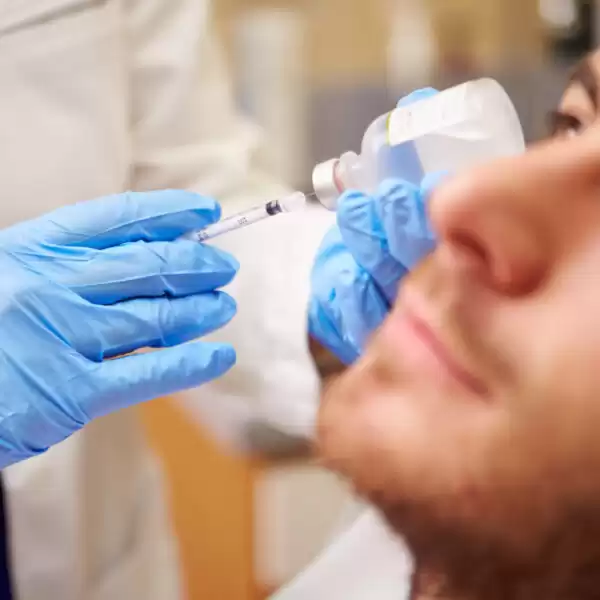 A man receives a Botox injection on his face.