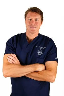 An award-winning Las Vegas surgeon in scrubs posing for a photo.