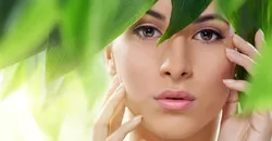 A woman receiving a Laser Genesis treatment with green leaves covering her face.