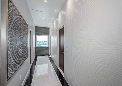 A hallway with white walls and a large painting.