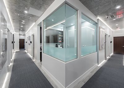 A hallway in a modern office with glass walls.