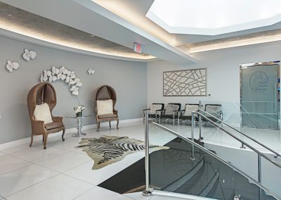 The lobby of a medical office with chairs and a staircase.