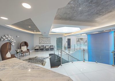 A lobby with a marble floor and a glass ceiling.