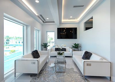A living room with white couches and a coffee table.