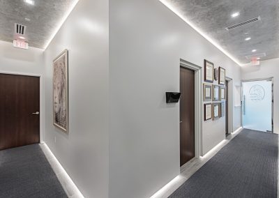 A hallway in a medical office with framed pictures.