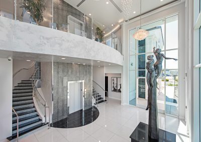 The lobby of a modern building with a staircase and a statue.