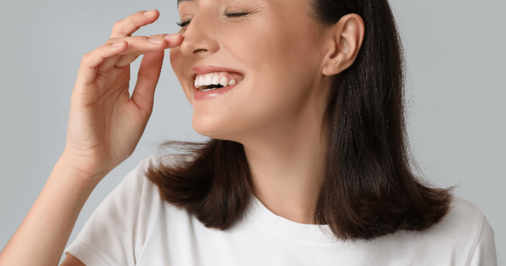 5 Things to Know About Rhinoplasty in Las Vegas: Cost, Recovery & Results 1 Smiling woman touching nose after rhinoplasty, happy with results and cost