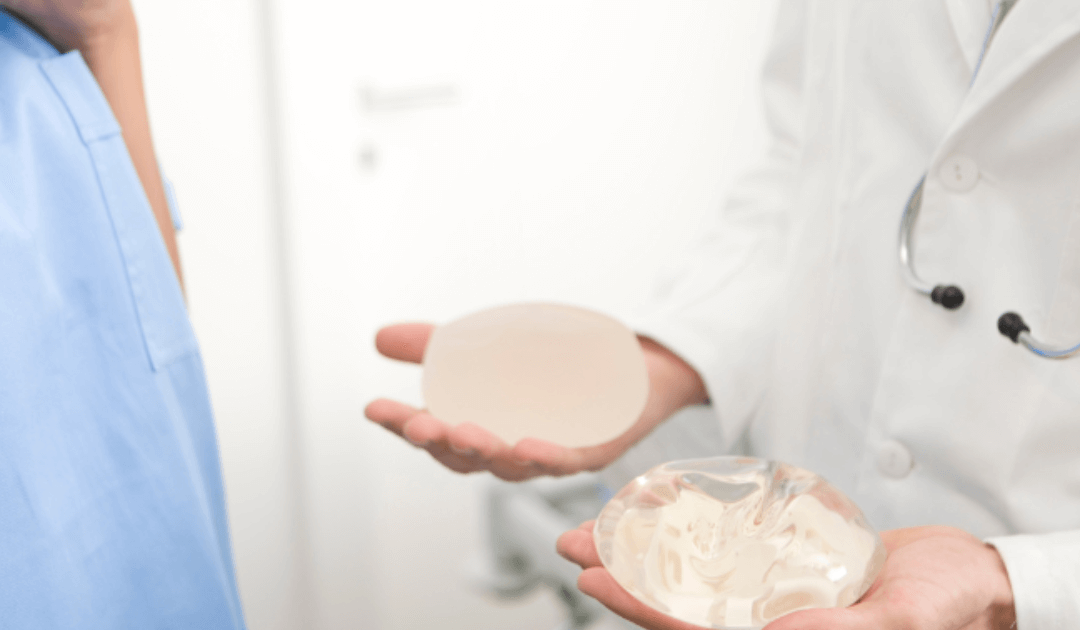 Board certified surgeon showing different breast implant options during a personalized breast augmentation consultation in Las Vegas